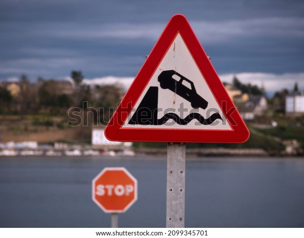 Horizontal view of warning traffic sign of end of\
road and fall into the\
sea.