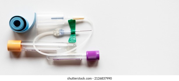 horizontal white background with copy space with medical material consisted in test tubes, tourniquete and needle for blood collection