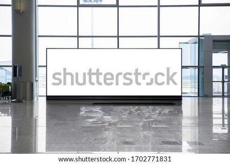 Horizontal white blank led billboard for advertising banners on the floor in front of windows in a shopping mall.