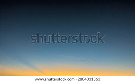 A horizontal wide angle perspective captures a dark dawn morning sky transitioning into a bright orange yellow sunrise gradient on the horizon line. The simple natural landscape layout template creates a beautiful minimalist presentation backdrop with open copy space.