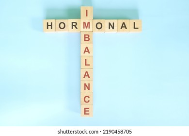 Hormonal Imbalance Concept. Wooden Blocks Crossword Puzzle Flat Lay In Blue Background.