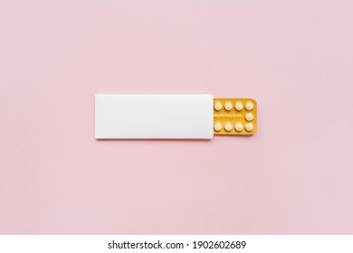 Hormonal oral contraceptives pills in a blister for a month of reception lie on pastel pink background. Flat lay, top view, copy space.