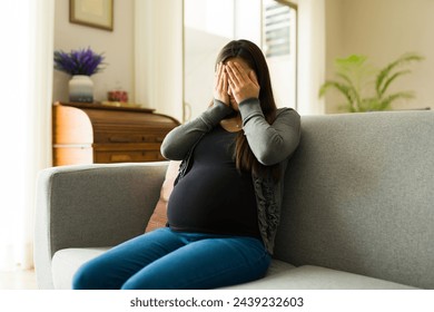 Hormonal pregnant woman crying and feeling sad at home and having negative emotions while worried about motherhood and health  - Powered by Shutterstock