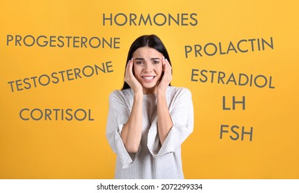 Hormones imbalance. Stressed young woman and different words on yellow background