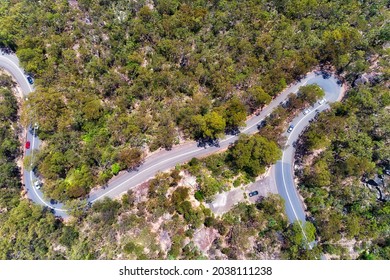 Hornsby heights Galstone road across Berowra creek in narrow and winding path - aerial top down view over gum-tree woods.