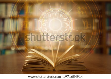 Horoscope astrology, Zodiac sign and constellation study for foretell and fortune telling education course concept with horoscopic wheel over old book in school library.