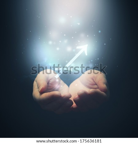 Horoscope Sagittarius sign, female hands opening to light and holding zodiac symbol