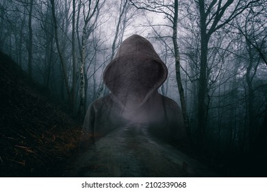 A horror concept of a double exposure of a scary hooded figure with no face. In a moody, foggy forest on a winters evening         