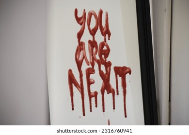 The horror concept of an inscription on a glass that reads you are next. - Shutterstock ID 2316760941