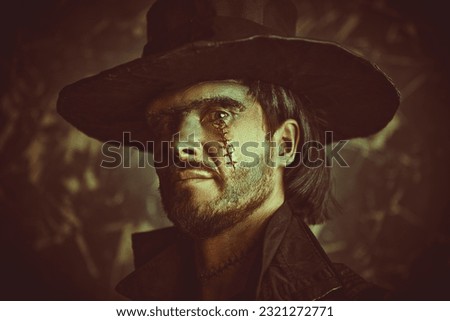 Horror, fantasy. Portrait of a scary bearded man with scars on his face and neck in a black leather hat and black coat, who looks with evil eyes into the camera. 19th century style. Halloween.