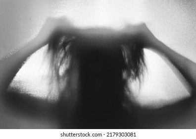 Horror ghost woman behind the matte glass. Halloween festival concept. - Shutterstock ID 2179303081