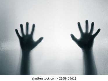 Horror, halloween background - Shadowy figure hands behind glass - Shutterstock ID 2168403611