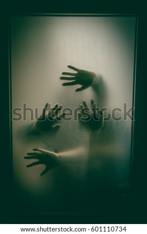 Horror hands. Silhouettes through glass