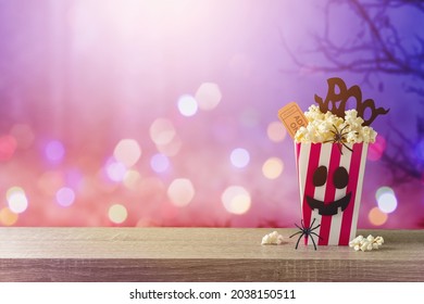 Horror Movie Night And Halloween Party Concept With   Popcorn On Wooden Table Over Scary Background