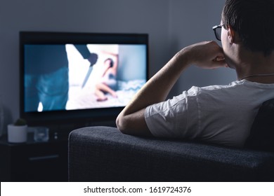 Horror Movie Stream On Tv. Man Watching Scary Film Or Series On Online Streaming Or VOD Service In Dark Home Living Room At Night. Scared Person Enjoying Thriller. Fan Of Digital Entertainment.