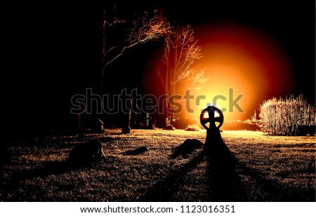 Horror night light in cemetery on Halloween