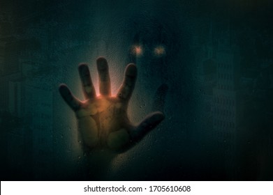 Horror Scene Of A Man With Hand Against Wet Shower Glass And Dark Cityscape Background. Toned Image. Horror Concept