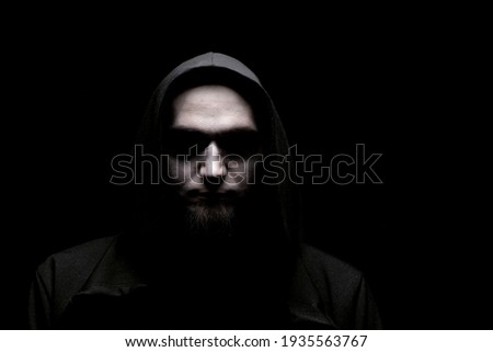 Horror scene with scary human face. A creepy man with no eyes in a black hood. 
