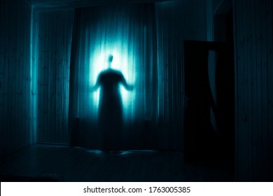 Horror silhouette in window with curtain inside bedroom at night. Horror scene. Halloween concept. Blurred silhouette of ghost - Shutterstock ID 1763005385