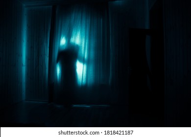 Horror silhouet in raam met gordijn in de slaapkamer's nachts. Horrorscene. Halloween-concept. Wazig silhouet van geest
