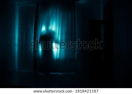 Horror silhouette in window with curtain inside bedroom at night. Horror scene. Halloween concept. Blurred silhouette of ghost Foto stock © 