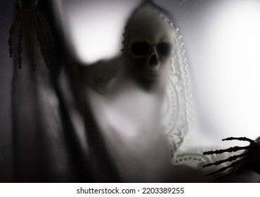 Horror Skeleton Or Grim Reaper Behind The Matte Glass. Halloween Festival Concept.Blurred Picture