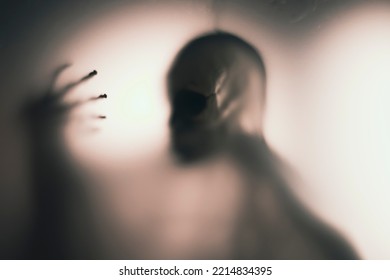 Horror Skeleton Or Grim Reaper Behind The Matte Glass. Halloween Festival Concept.Blurred Picture