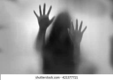 Horror woman behind the matte glass in black and white. Blurry hand and body figure abstraction. - Shutterstock ID 421377721