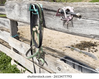 Horse bridle and barn tools on rustic wooden fence in rural farm setting. - Powered by Shutterstock - Get 15% off with code: PIKWIZARD15