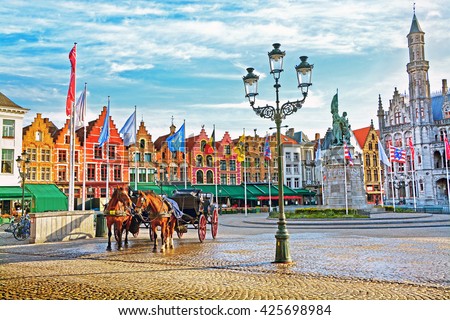 Horse carriages on Grote Markt square in medieval city Brugge at morning, Belgium.