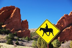 Horse Crossing Sign In Front Of Rock Formations