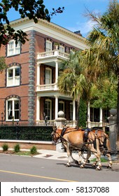 A Horse Drawn Carriage Passes By A Historic House In Charleston, South Carolina.