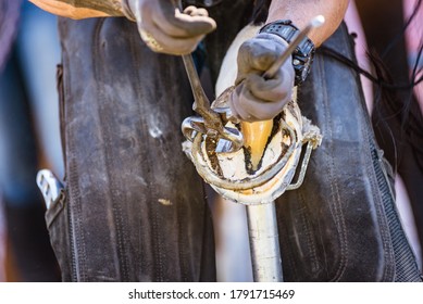 Horse farrier at work - trims and shapes a horse's hooves using farriers pincers, rasper and knife. The close-up of horse hoof.