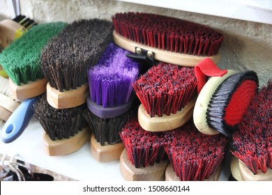 Horse grooming brushes piled on a shelf - Powered by Shutterstock