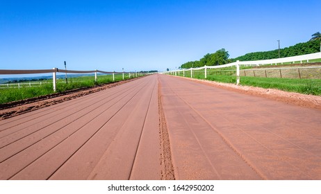 Horse Racing Smooth Sand Training Track For Mammals Straight   Looking Distant Low Photo Perspective  Closeup In Morning Blue Sky Outdoors Countryside Panoramic Diminishing Landscape.