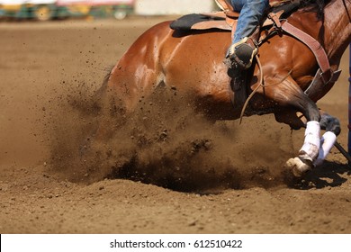 A Horse And Rider At A Barrel Racing Event With Dirt Flying.