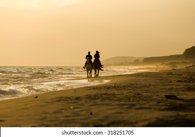 Horse Rider Couple At Sunset Beach, Next To The Sea