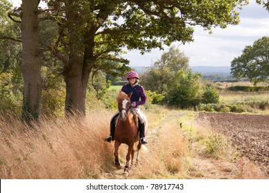 Horse And Rider Enjoying A Canter In The English Countryside On A Summers Day.