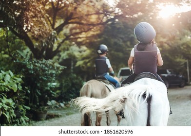 Horse Rider.Back View Kids Learn To Ride A Horse.Happy Asian Kid Girl Riding Horse In Horse School Farm Club.Horseback Riding, Lovely Powerful Equestrian.Cowgirl Kid Fun In Farm.Kids Activity.Animals.