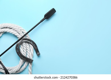 Horse Riding Crop With Rope And Horseshoe On Color Background