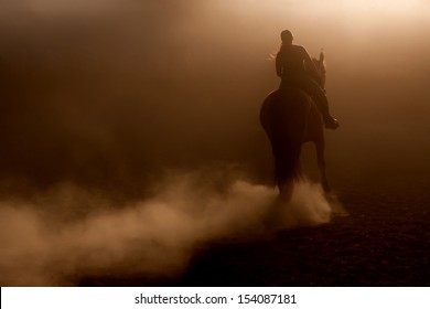 Horse riding in the dust with backlighting - Powered by Shutterstock