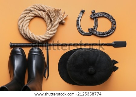 Horse riding helmet, boots and crop with rope and horseshoes on color background Stock photo © 
