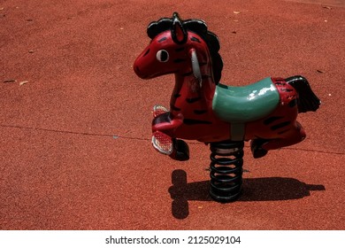 Horse Shape Bouncy Spring Rider On Sunny Summer Day On Colorful Kids Playground Background