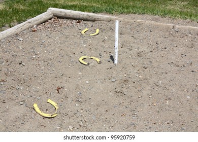 Horse Shoe Game In Field With Log Sandbox