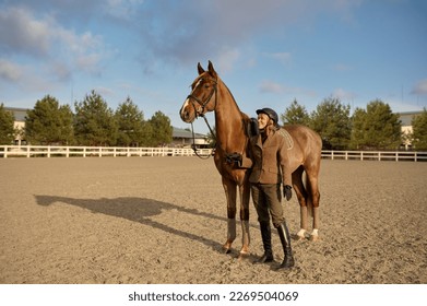 A horse trainer with her stallion outdoors in farm - Powered by Shutterstock