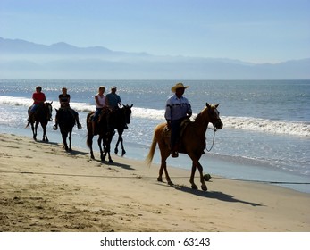 Horseback Riders At The Beach