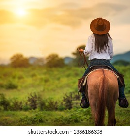 horseback riding from behind overlooking wide open field and mountains  - Powered by Shutterstock