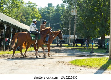 Horseback Riding In A Stable Before The Saratoga Horse Race. Beautiful Shot Of 2 People On Brown-haired Horses In The Sunlight. Saratoga Springs, New York, USA. November 2013.