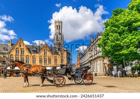 Horse-drawn carriage cart on cobblestone Burg square, medieval buildings and Belfry of Bruges Belfort van Brugge bell tower in Brugge old town, Bruges city historical centre, Flemish Region, Belgium