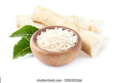 Horseradish root and grated horseradish in wooden plate on white background